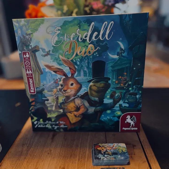 Die Everdell-Duo-Schachtel auf einem Holztisch, davor ein Kartenstapel