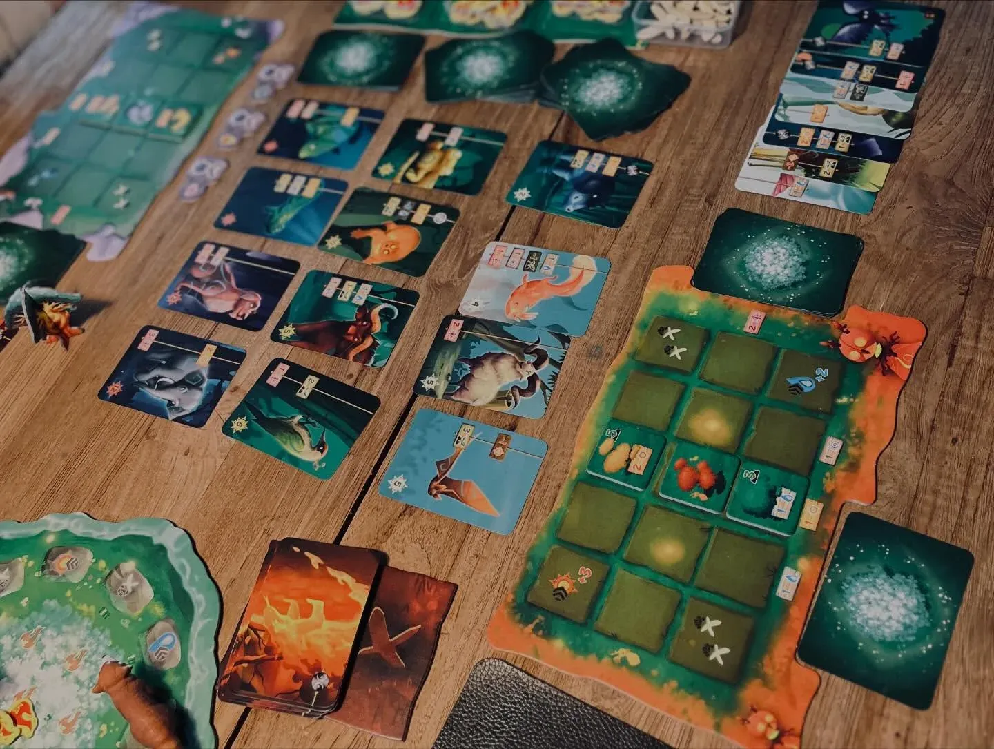 Eine laufende Partie Living Forest: Spielertableaus und Tierkarten auf dem Tisch