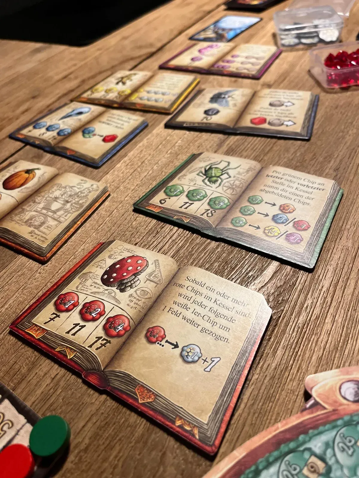 Aufgeschlagene Zutatenbücher von Die Quacksalber von Quedlinburg auf dem Tisch