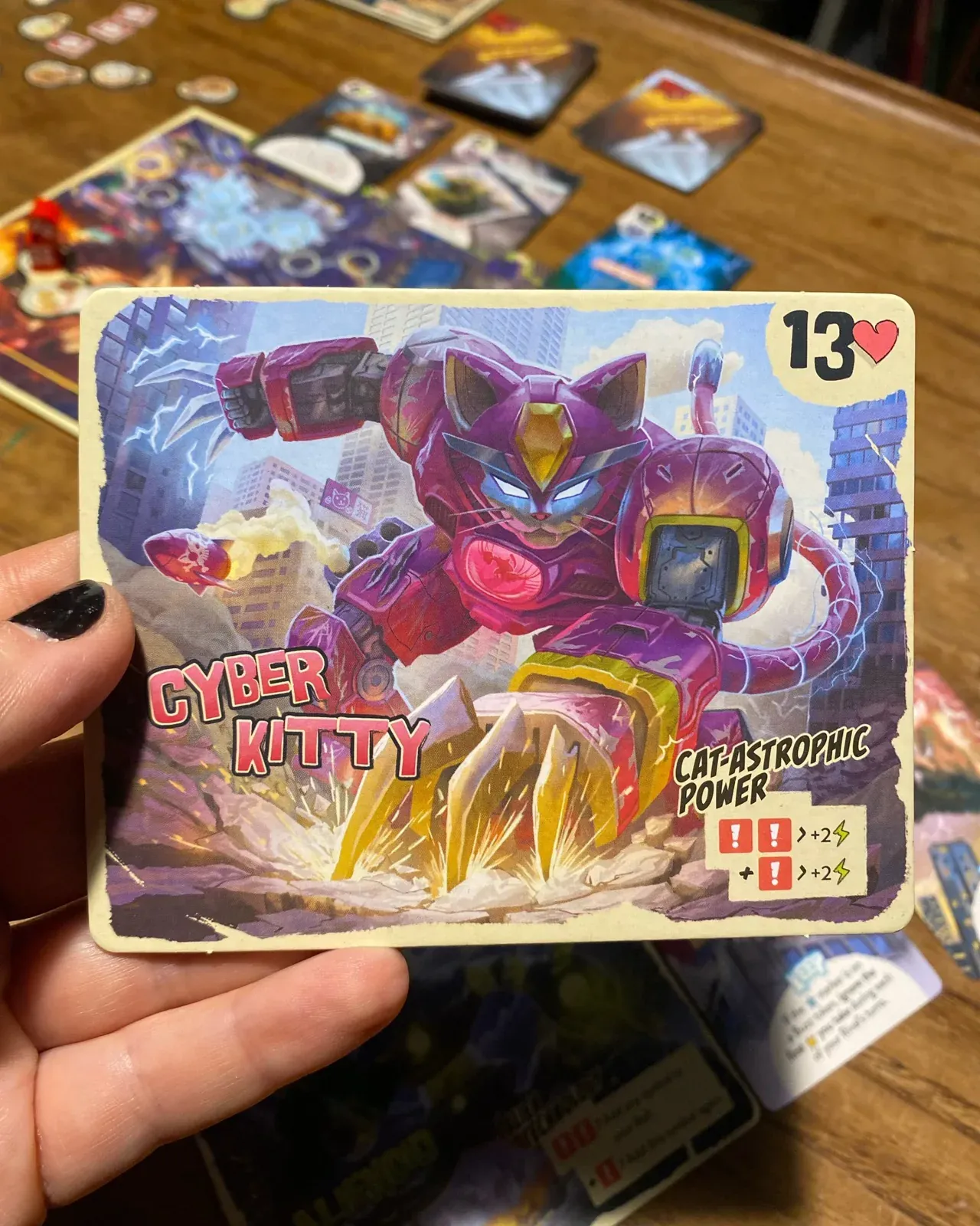 A hand holding the Cyber Kitty monster card