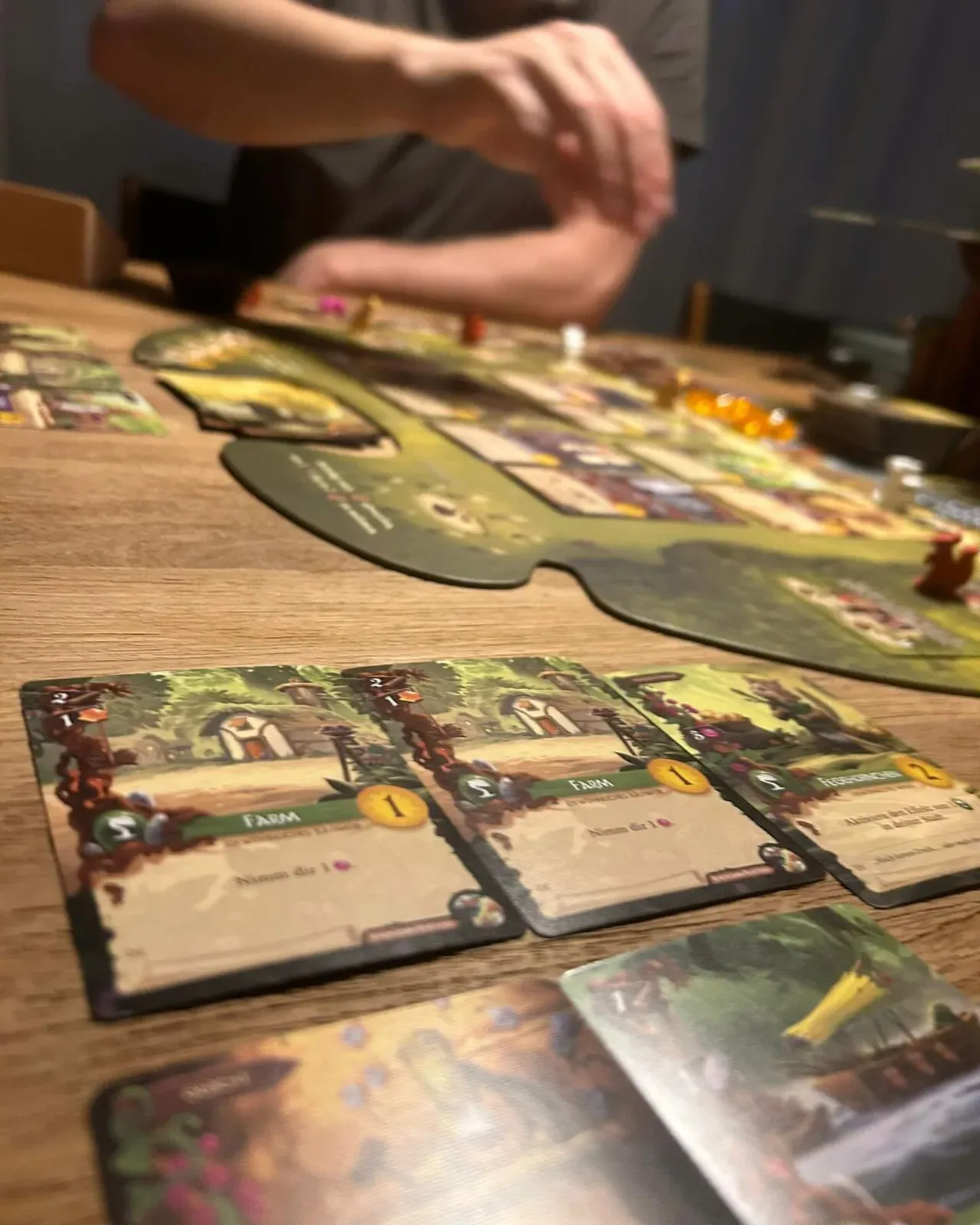 Nahaufnahme von Everdell-Karten und der Wiese auf dem Spielplan