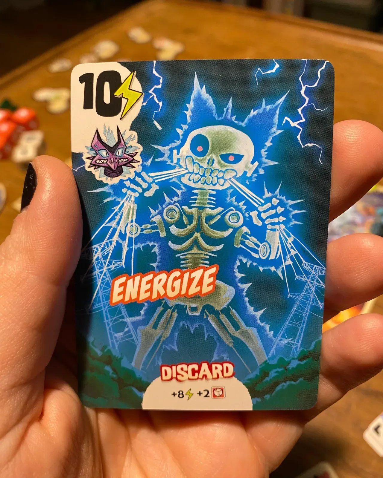 A hand holding the Energize power card