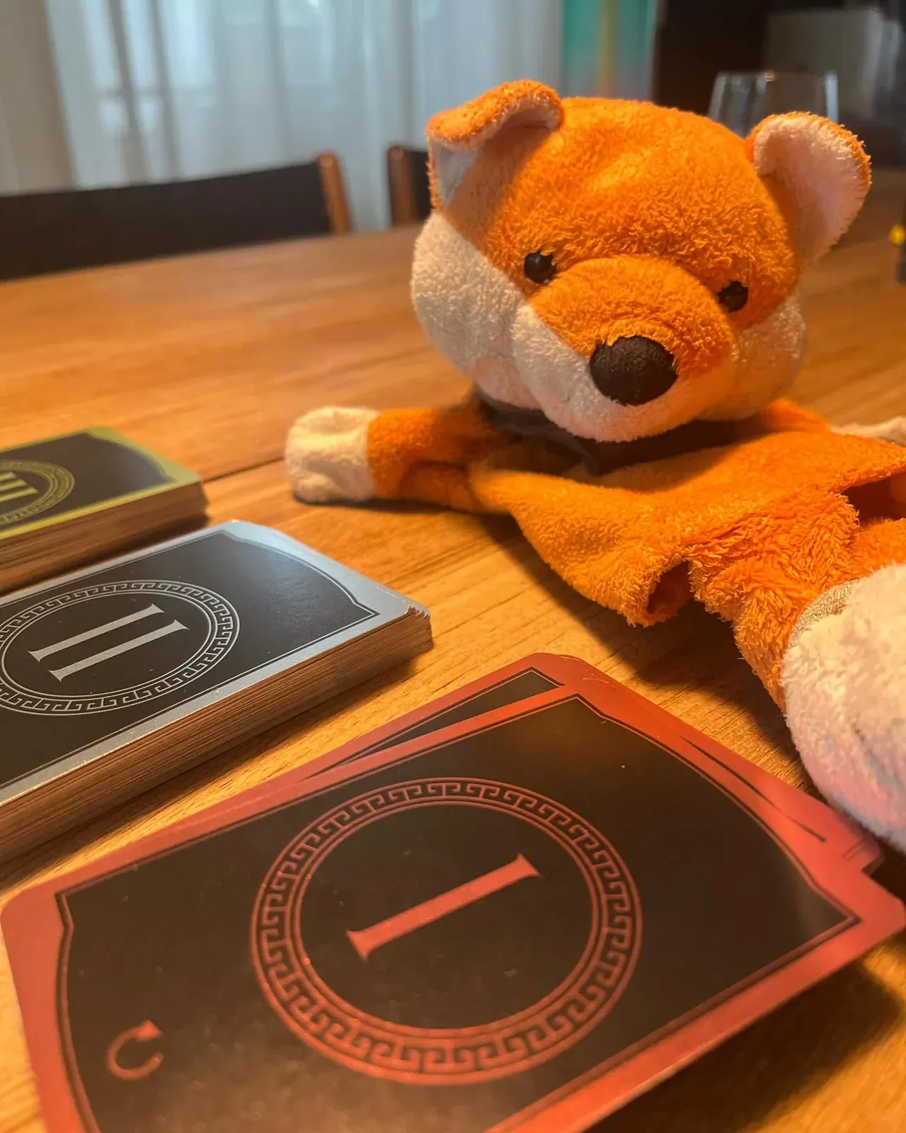 7 Wonders cards next to a plush fox