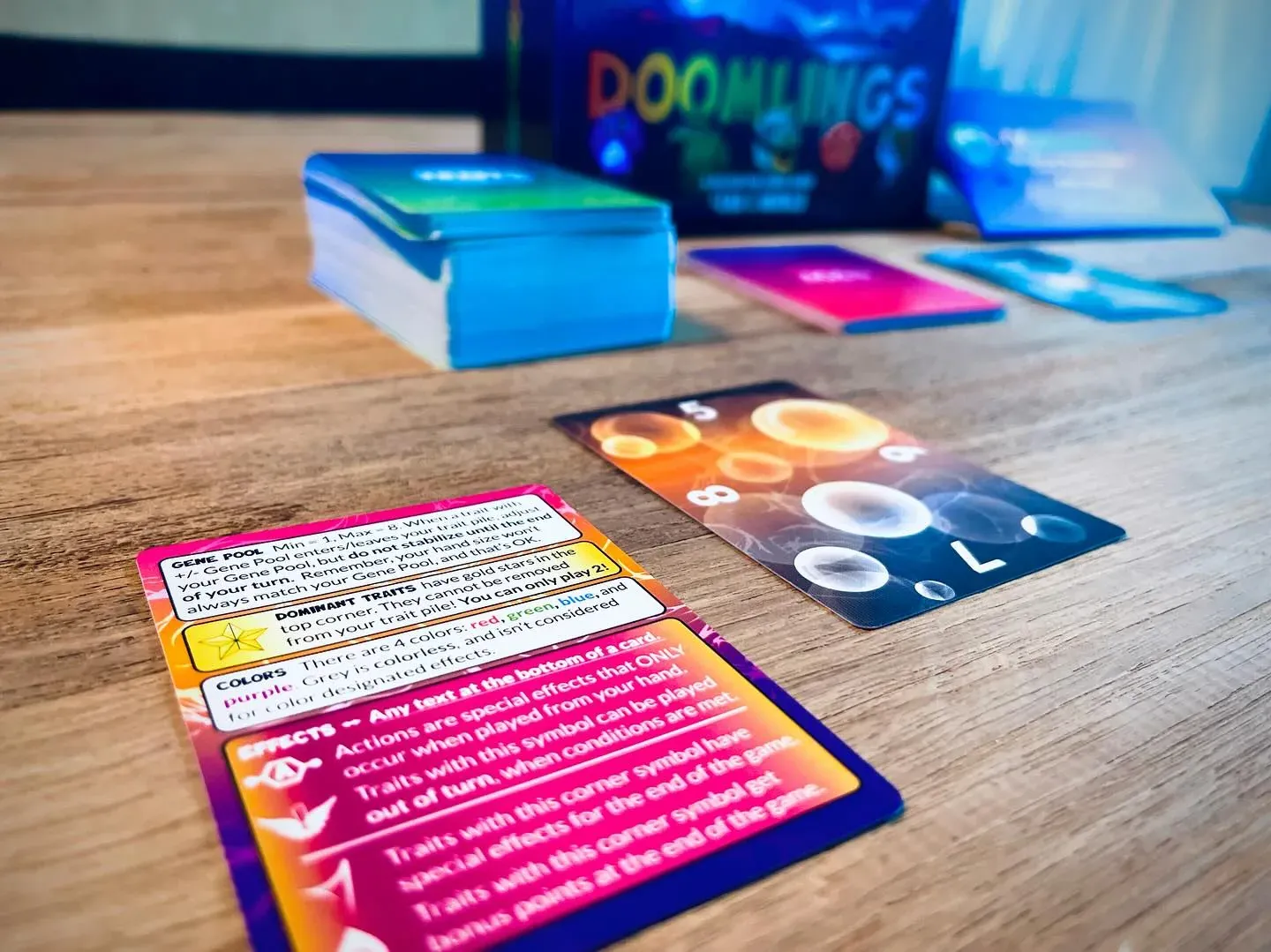 Doomlings-Karten und Stapel verteilt auf einem Holztisch
