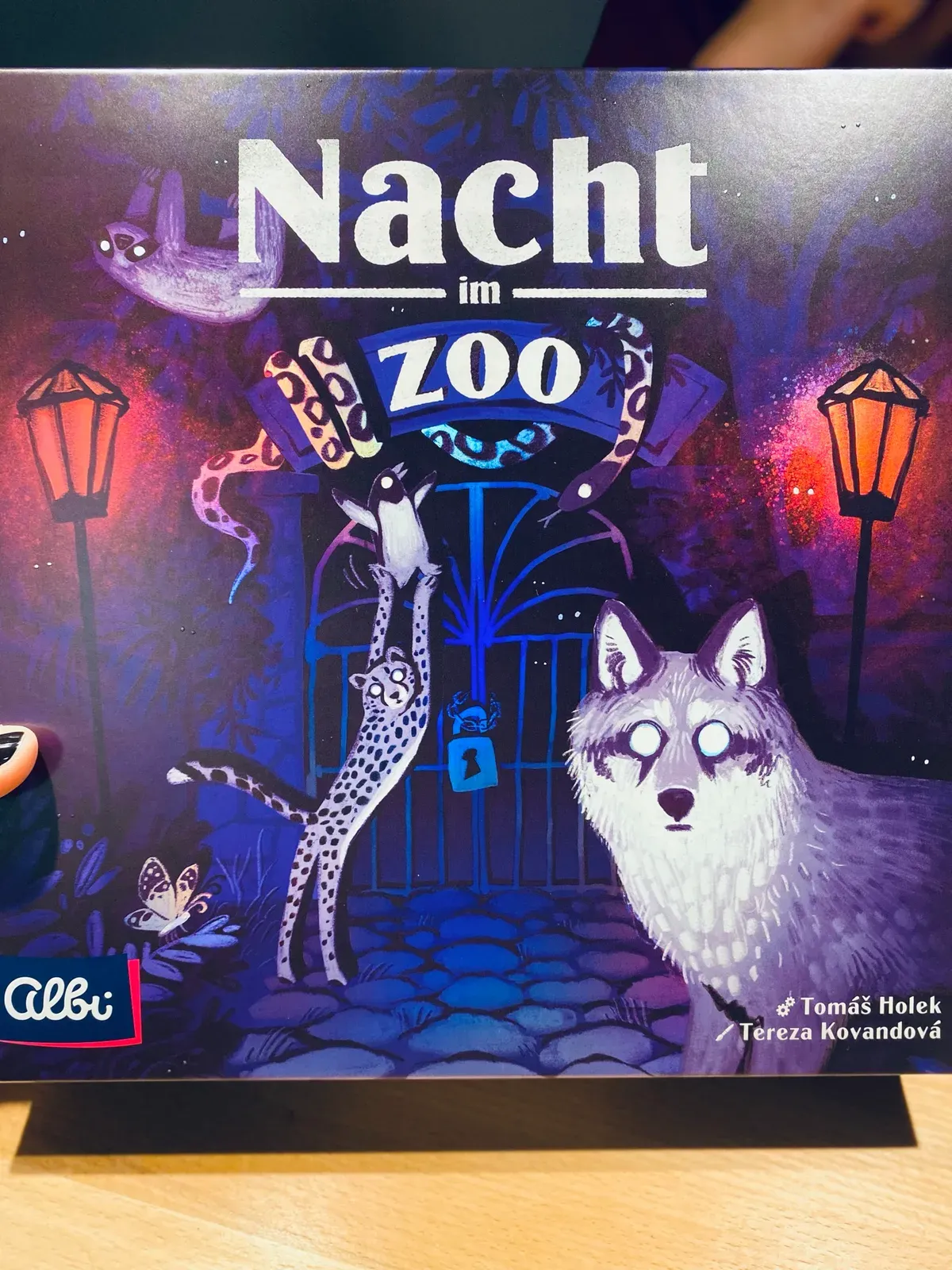 Das Cover von Nacht im Zoo mit einem weißen Wolf vor dem Zootor